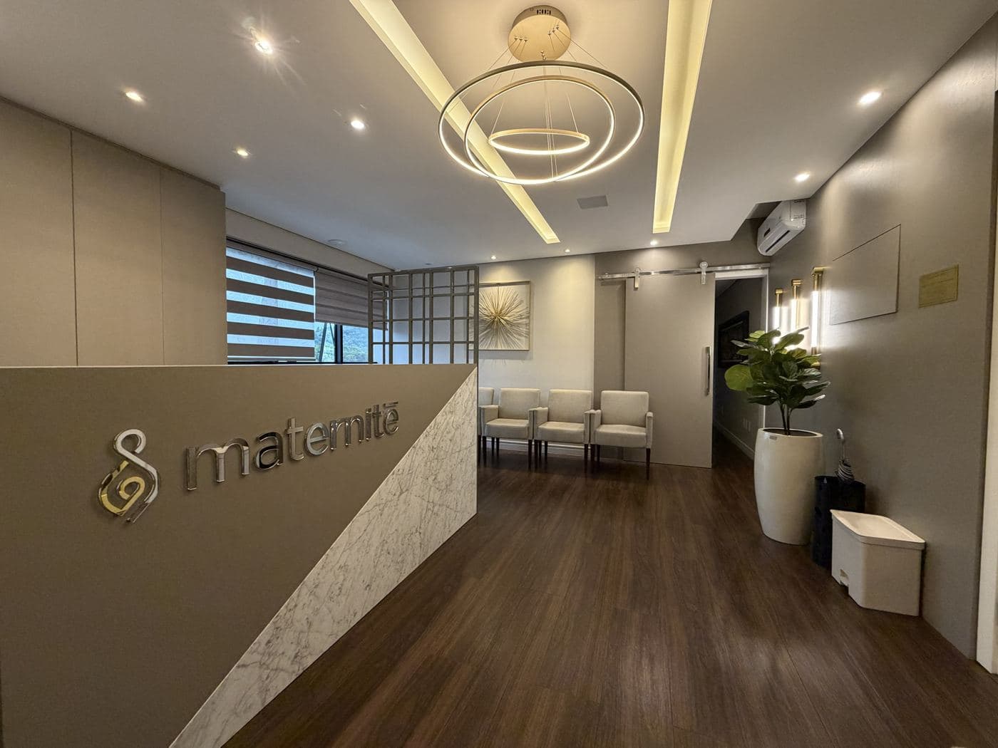 Recepção da Clínica Maternité, com balcão e sala de espera